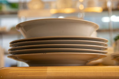 Close-up of bowl and plates stacked on table in restaurant