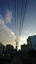 Cars on street in city against sky during sunset