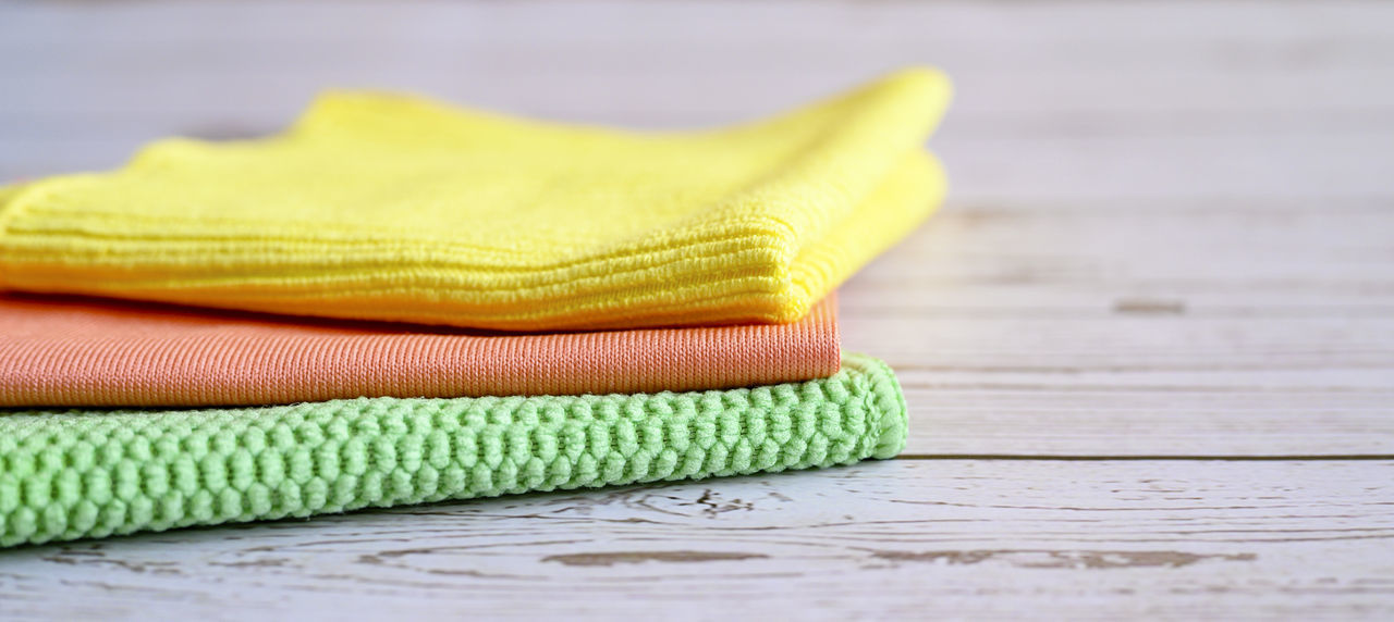 CLOSE-UP OF YELLOW STACK ON WOODEN TABLE