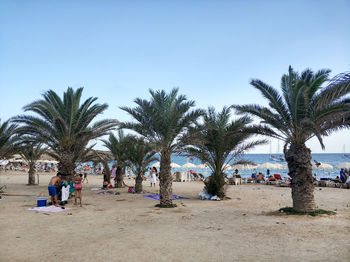 Group of people at beach against clear sky