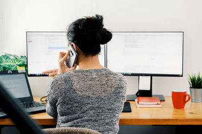 Rear view of woman using mobile phone