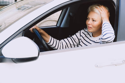 Portrait of young woman in car
