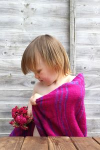 Cute girl with pink flower on wood