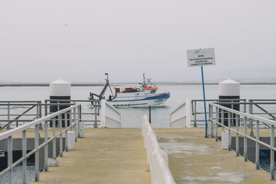 Railing by sea against clear sky