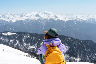 Rear view of woman looking at snowcapped mountain