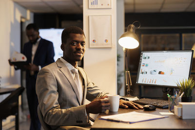 Portrait of young man using digital tablet in office