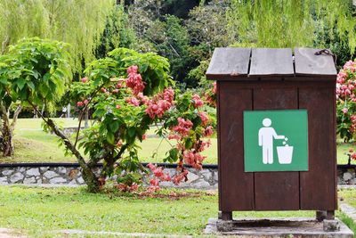 Information sign on green plant against trees