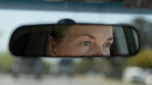 Close up of woman eyes in car mirror
