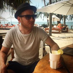 Portrait of mid adult man sitting on table at beach