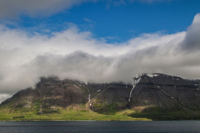 Scenic view of lake by mountain against sky