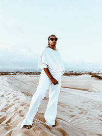 Young man wearing sunglasses standing on beach