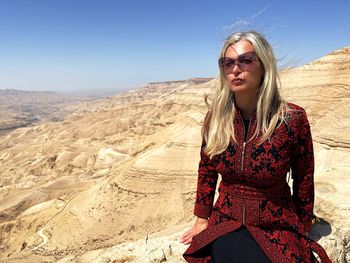 Young woman standing against mountain