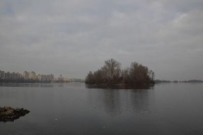 Scenic view of lake against sky in city