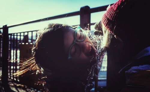 Close-up of girl drinking water from fountain