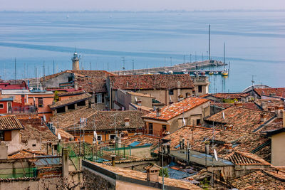 High angle view of townscape by sea against sky