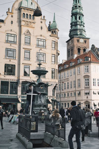 People on street against buildings in city