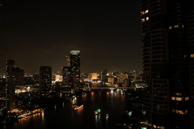 Illuminated buildings in city against sky at night