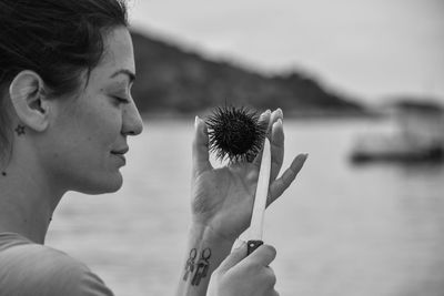 Woman holding sea urchins by lake