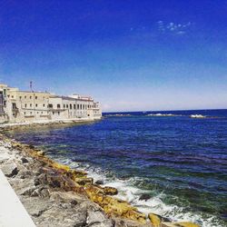 Scenic view of sea against clear blue sky