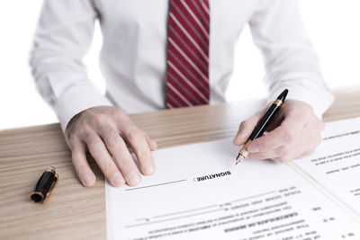 Midsection of man holding umbrella on table