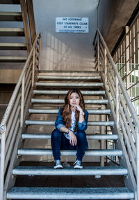 Portrait of confident stylish woman sitting on steps