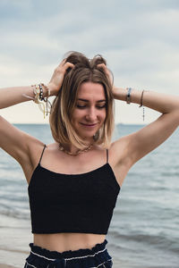 Young woman standing on blurred beachside background. attractive female enjoying walking the sea