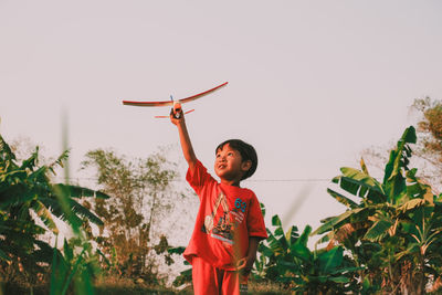 Rear view of woman standing against plants