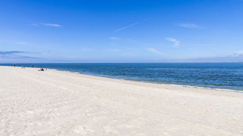 Scenic view of beach against blue sky