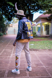 Rear view of man walking on footpath