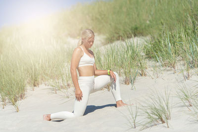 Full length of young woman on sand at beach