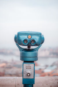 Close-up of coin-operated binoculars against sky