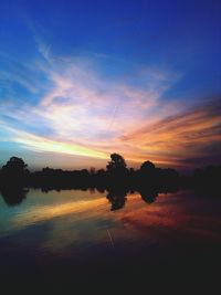 Scenic view of lake against sky at sunset