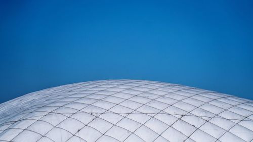 Low angle view of modern building against blue sky