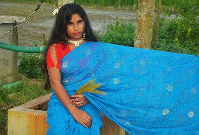 Portrait of girl wearing sari sitting outdoors