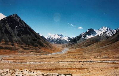 Scenic view of snowcapped mountains against blue sky