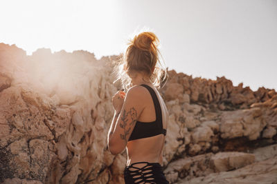 Side view of woman standing against sky during summer