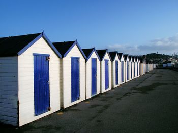 Beach huts in row against sky