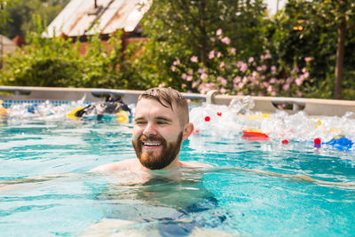 Portrait of smiling man swimming in pool