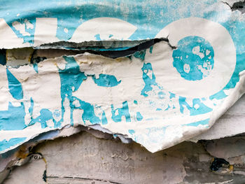 Close-up of torn poster on wall