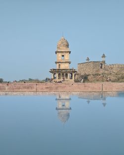 Reflection of ancient building in ancient pool against sky