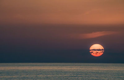 Scenic view of sea against orange sky