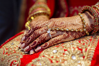 Midsection of bride with henna tattoo and jewelries