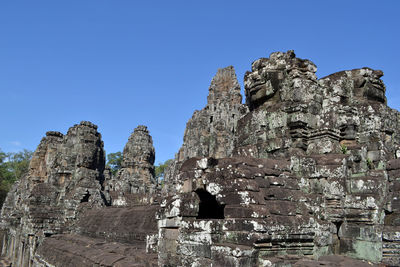 Low angle view of rock formation against clear blue sky