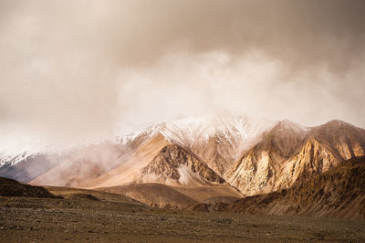 Scenic view of mountains against cloudy sky