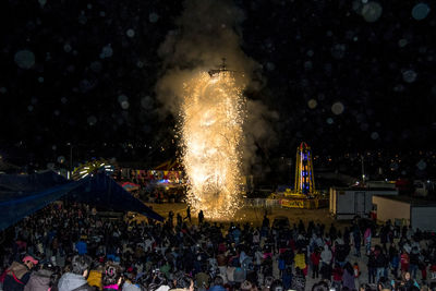 Crowd watching firework display at night