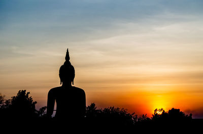 Silhouette statue against sky during sunset