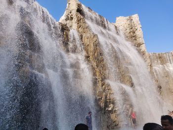 Low angle view of waterfall against sky