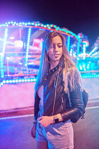 Portrait of smiling young woman standing at amusement park