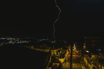 Illuminated cityscape against sky at night