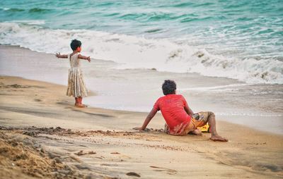 Rear view of boy playing at beach